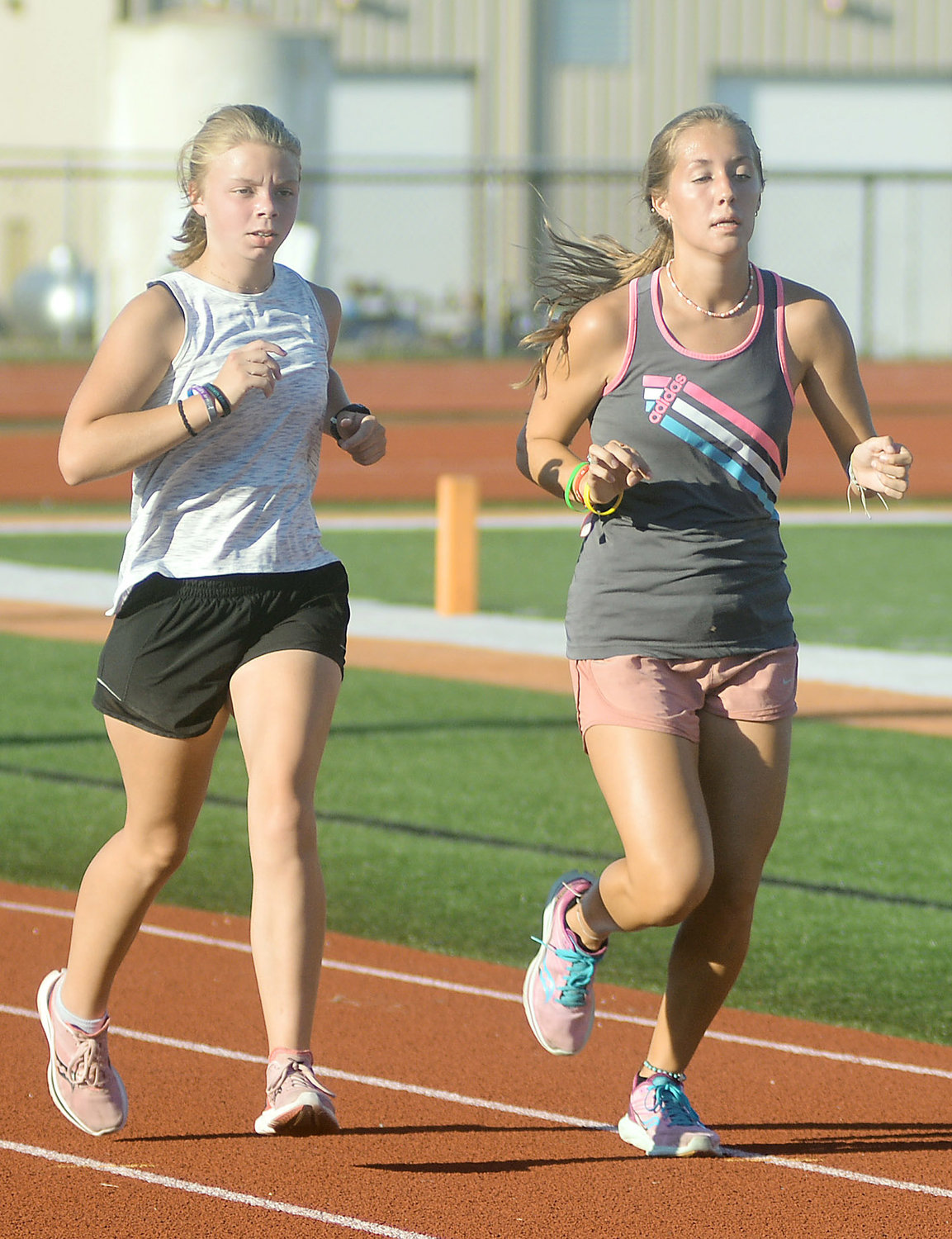Abbie Gibson and Kyah Weirich (above, from left) run around the Dutchmen Field track during a recent OHS Cross Country practice session.